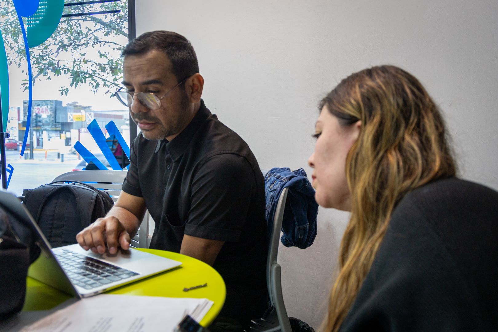 Dos integrantes del equipo revisan contenido en una laptop dentro de la cabina de Tec Sounds.