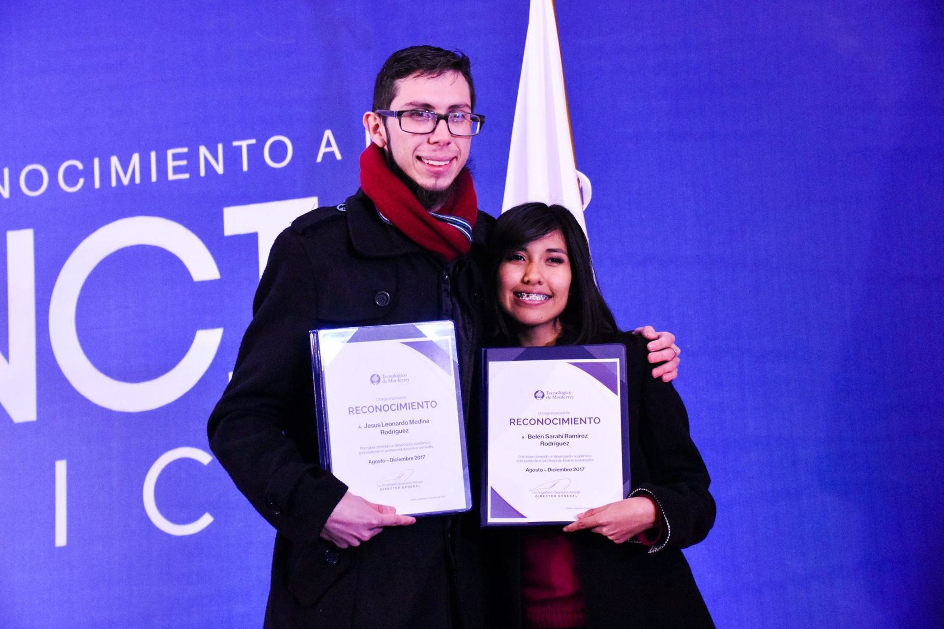 Pareja de Jóvenes abrazados con un diploma