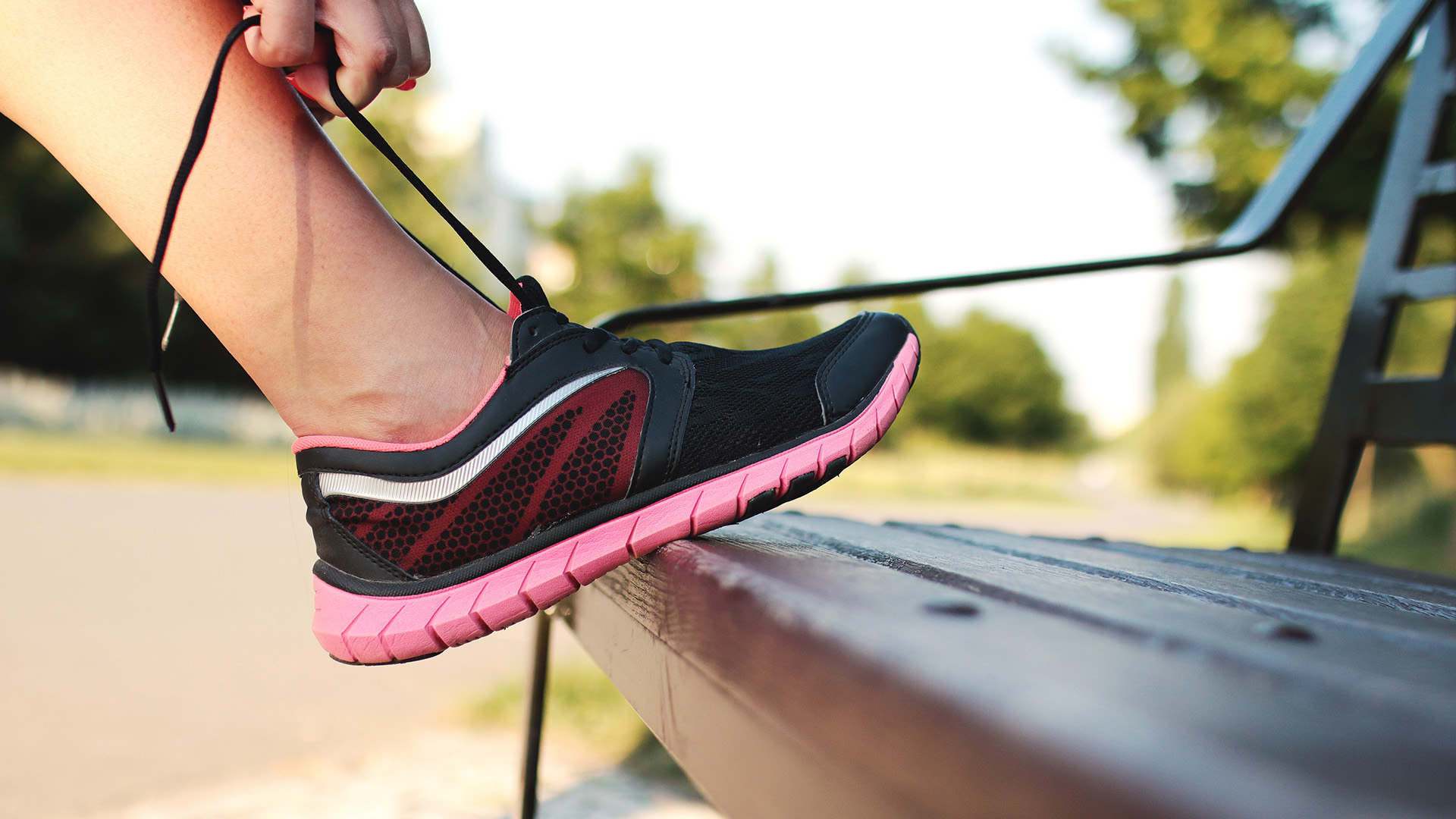 Persona amarrando las agujetas de sus tenis para correr