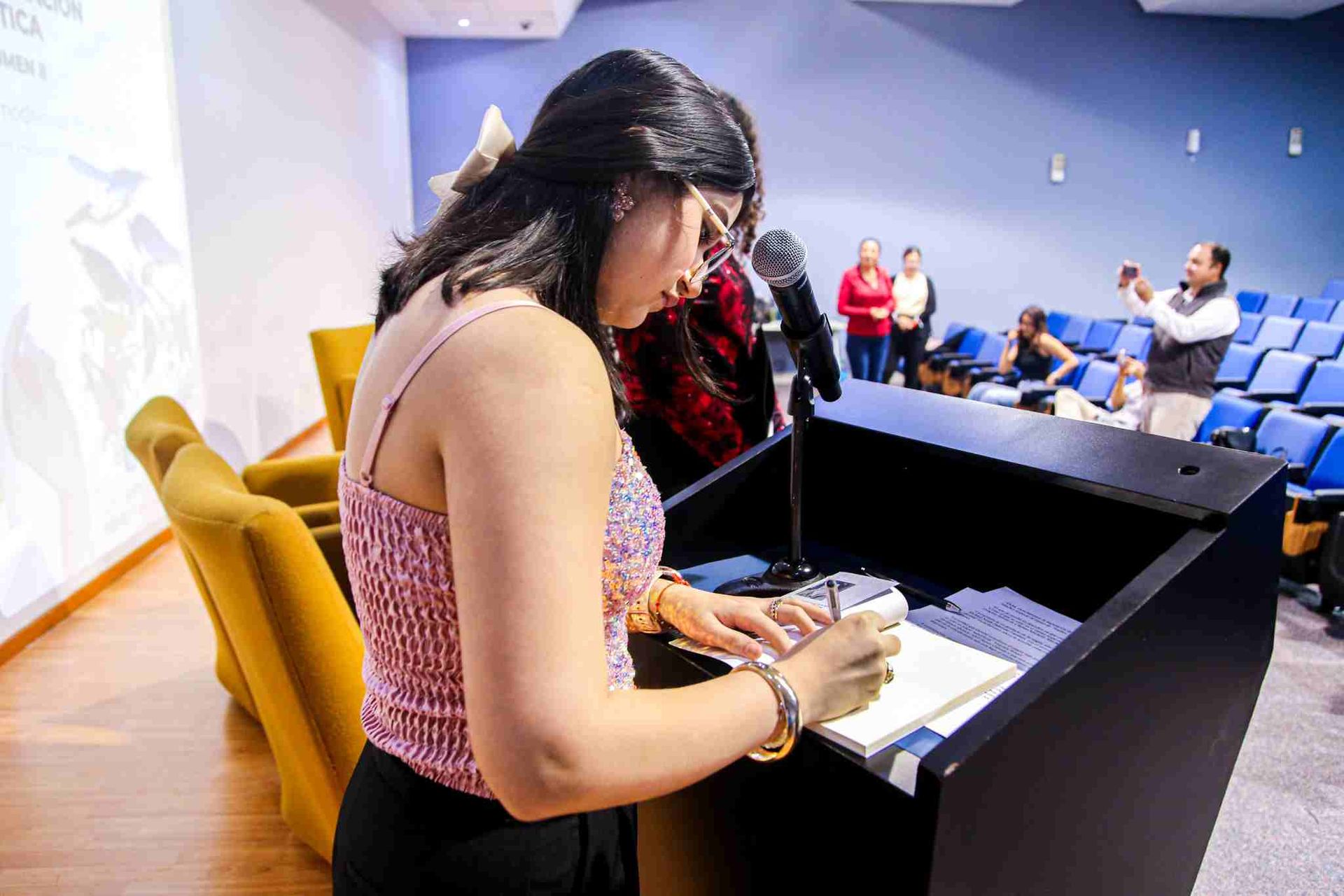 Alumna autografiando libro "Los nombres de la tarde".