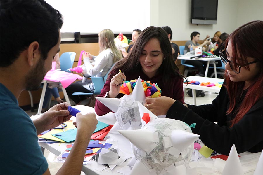 Alumnos decoran piñata en la actividad Viva México