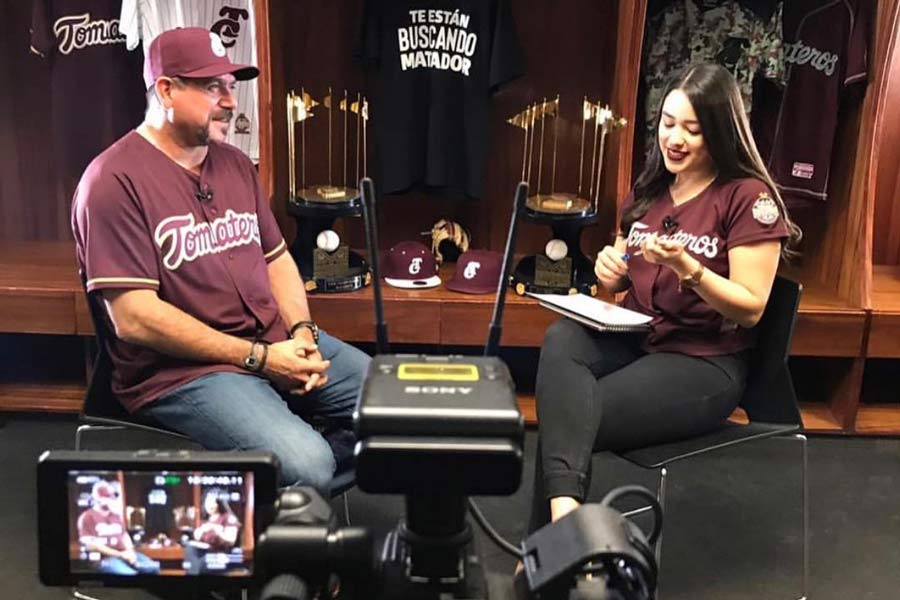 Valeria Cota realizando una entrevista a Benjamín Gil, mánager de Tomateros de Culiacán.