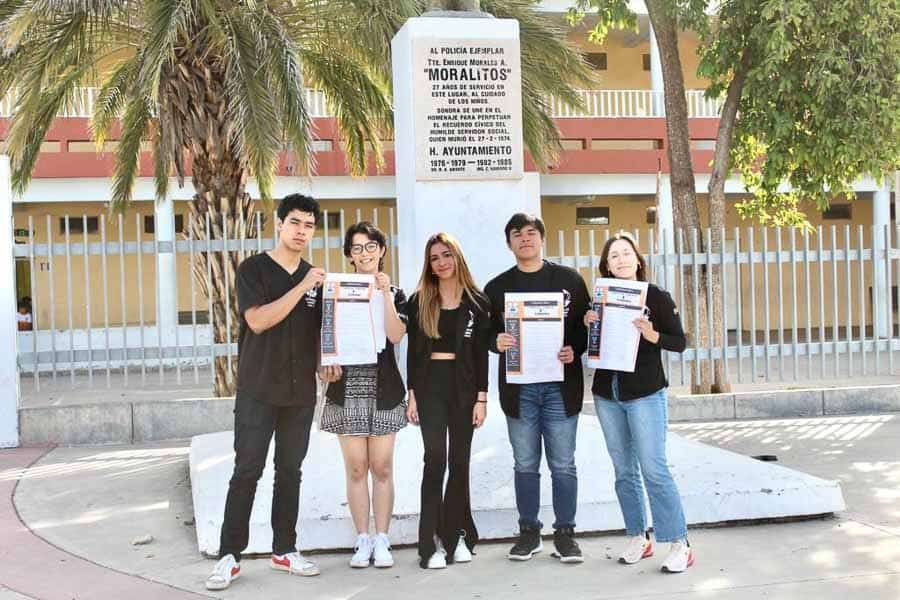 Estudiantes sonriendo ante la camara frente a la primaria Alberto Gutierrez