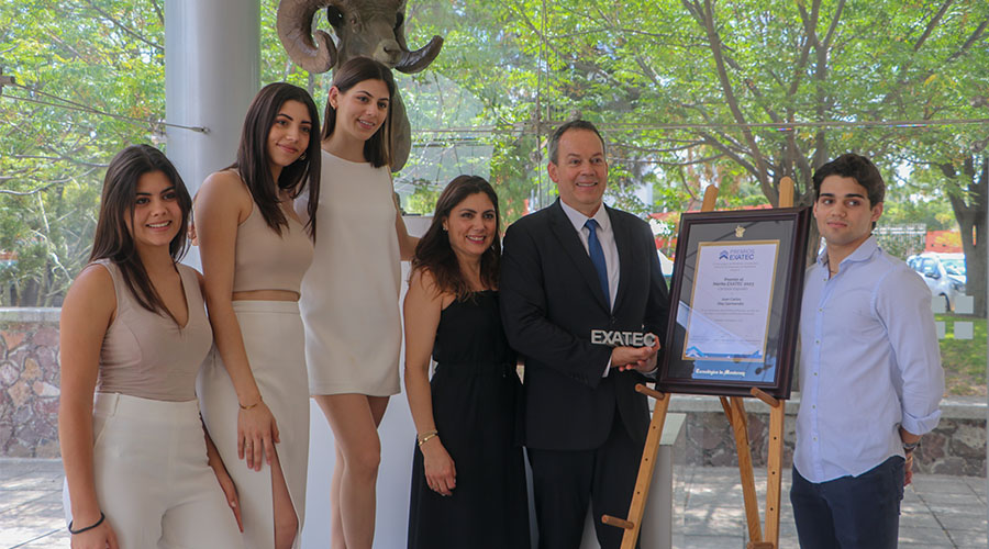 Juan Carlos y su familia posando con su placa de reconocimiento 