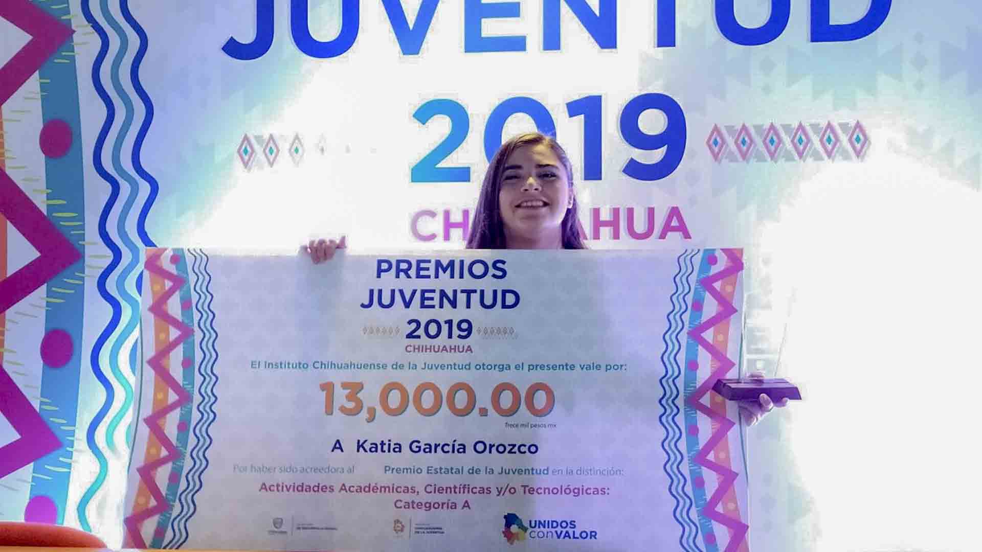 Katia sosteniendo cheque del premio