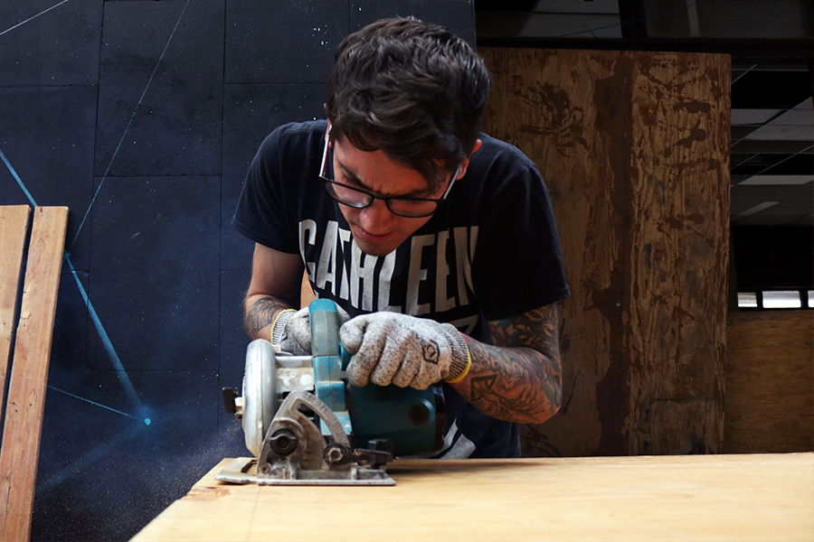 Un joven cortando un pedazo de madera en el nodo.jpg 