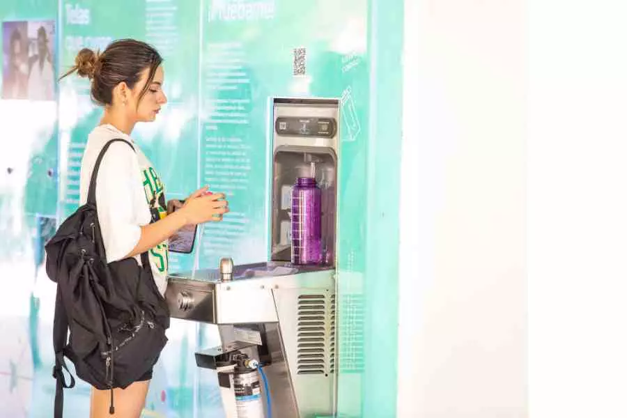 Alumna del Tec rellena su botella en un despachador de agua.