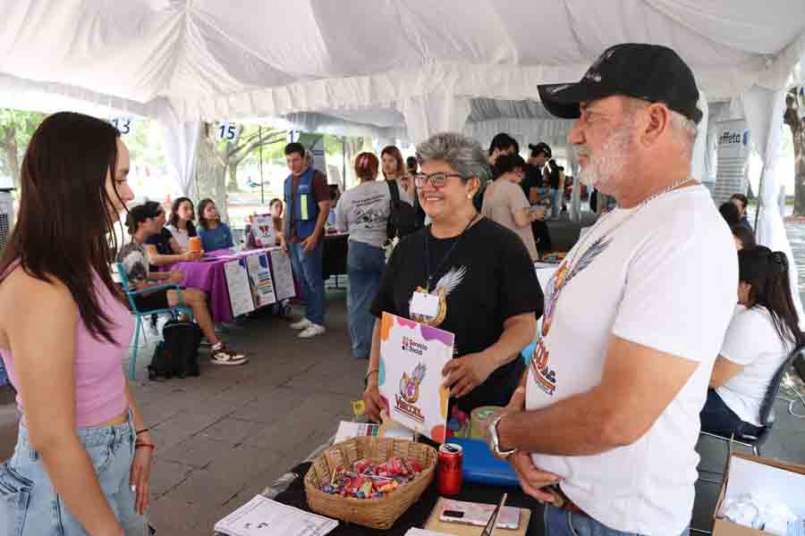 Alumna del Tec pide informes sobre un servicio social durante una feria de organizaciones socio formadoras.