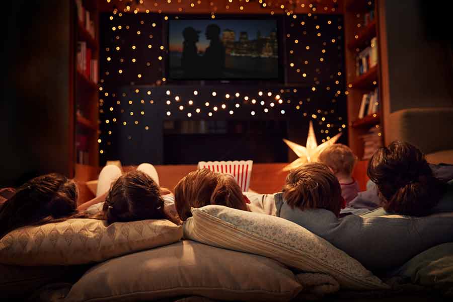 Papás y niños viendo una película en su casa