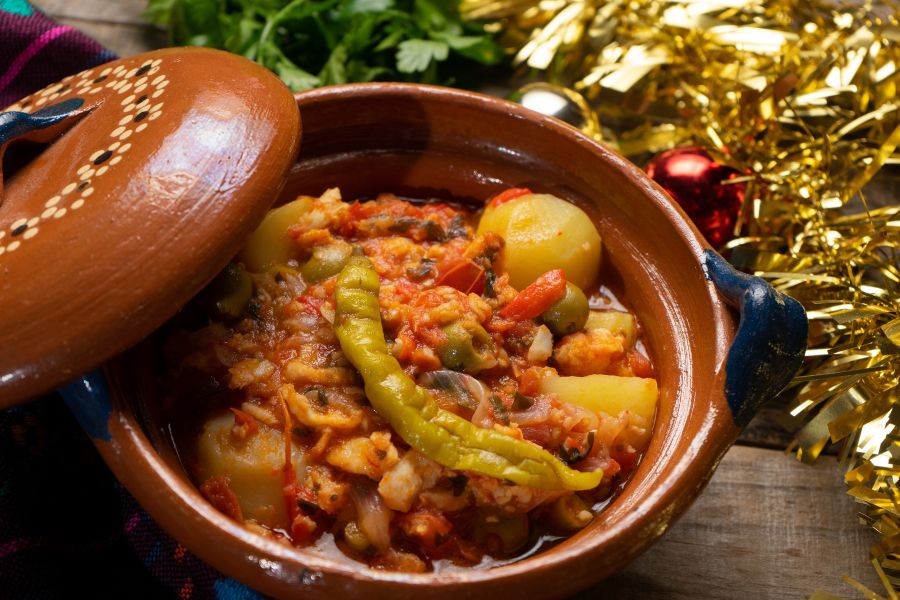 Bacalao a la vizcaína servido en cazuela de barro con papas, aceitunas y chile güero, un platillo típico de la Navidad en México