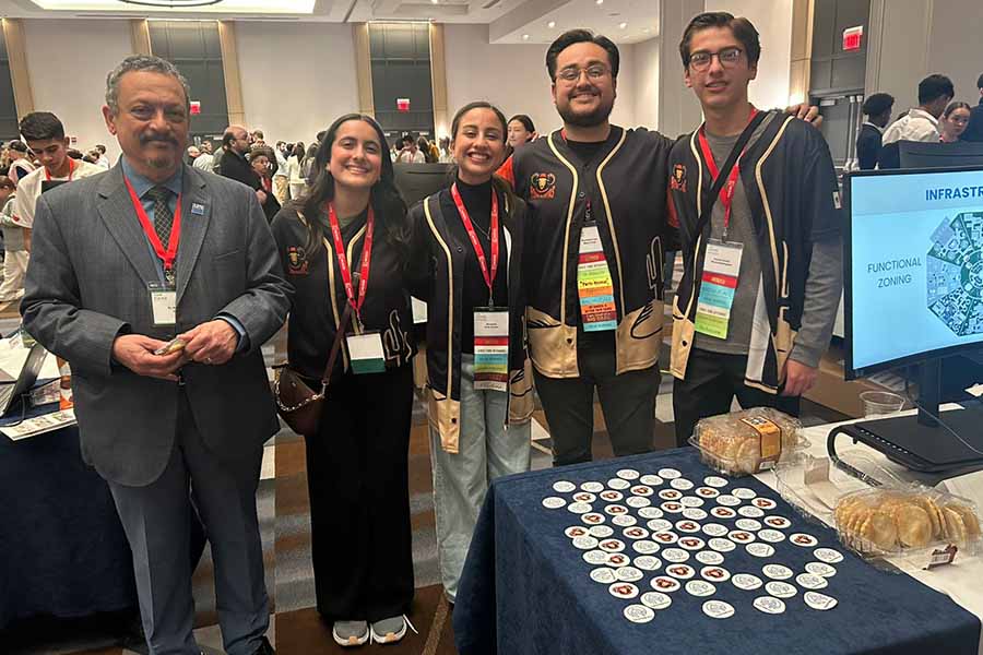 Grupo de 5 personas posando juntos en un sal&oacute;n de conferencias.
