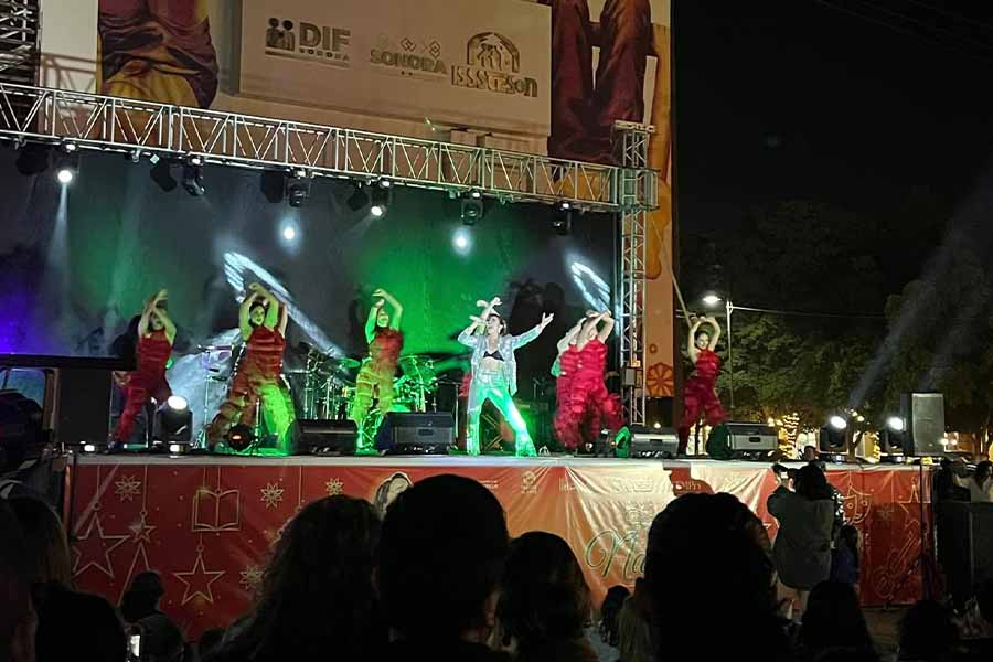 La cantante Caro Heredia sobre el escenario con sus bailarinas en el fondo.