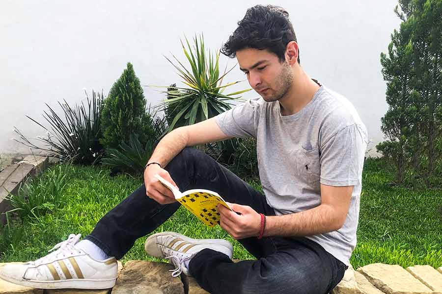 Alumno del Tec leyendo en su jardín durante la cuarentena por el coronavirus y el COVID-19