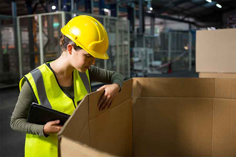 Trabajador inspeccionando una caja.