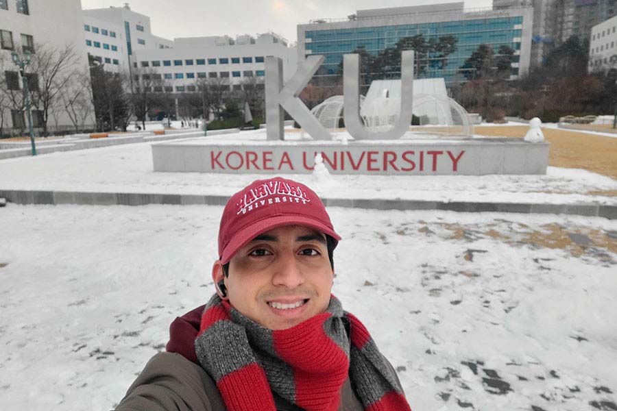 Estudiante del Tec de Monterrey en Korea University posa para una selfie con una gorra roja y un paisaje nevado en Seúl