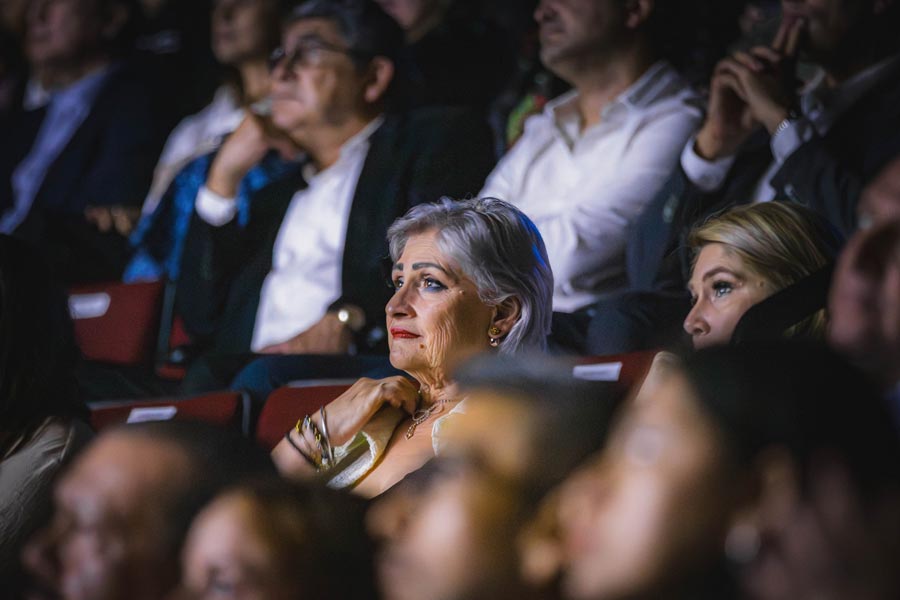 Mujer observa el documental de Eugenio con expresión de nostalgia y felicidad.