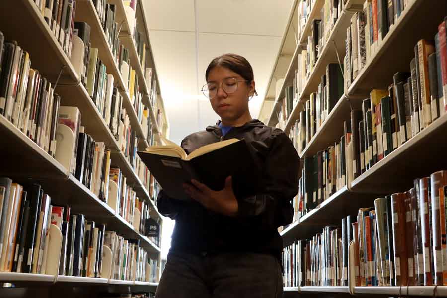 Viridiana lee un libro en la biblioteca del Tec, campus Monterrey.