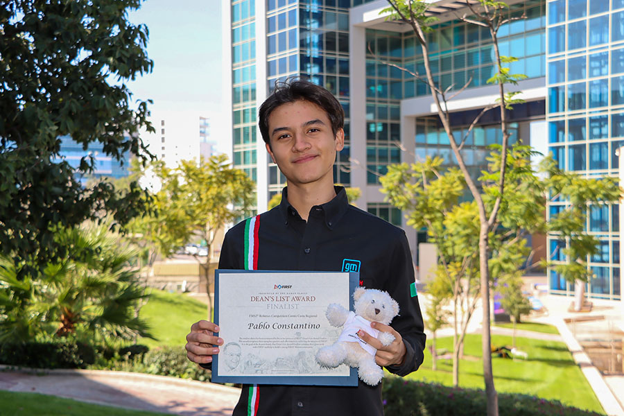 Pablo Constantino sosteniendo su reconocimiento que lo acredita como finalista del Dean’s List Award