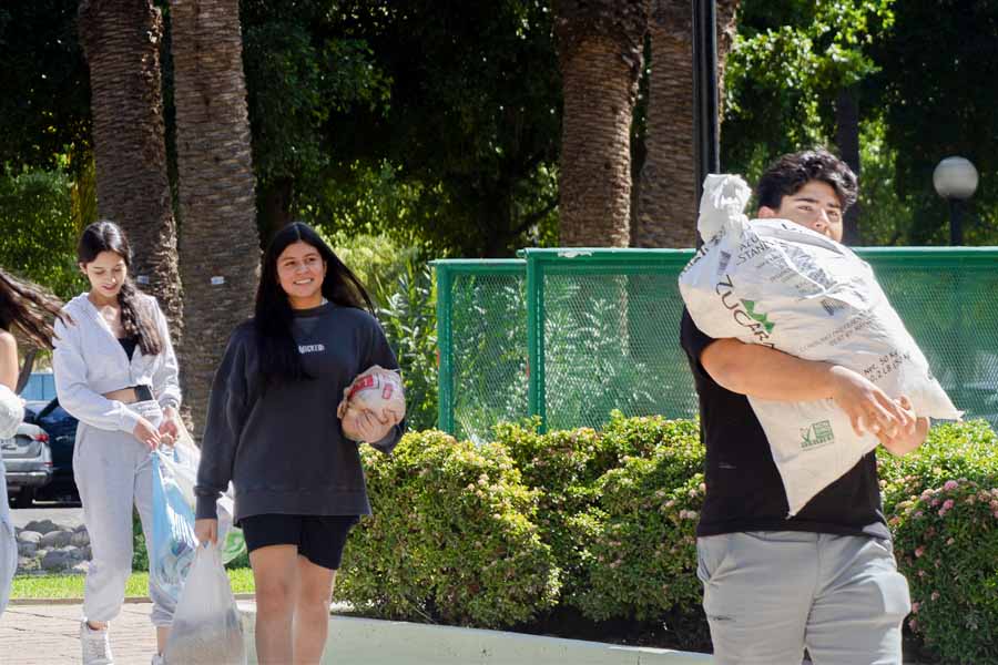 estudiantes cargando costales para colecta de alimentos