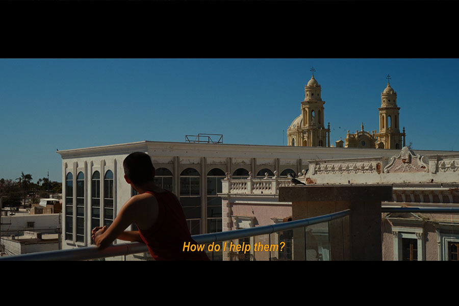 Escena del cortometraje donde el personaje de Rubén aparece de espaldas en una terraza viendo una vista de Hermosillo. 