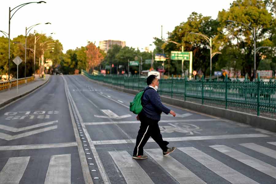 Hombre mexicano cruzando una avenida, sin flujo vehicular debido a la contingencia por el COVID-19