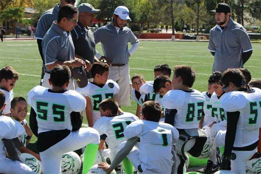 Impulsor del futbol americano, entrenando niños