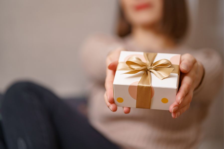 Mujer sosteniendo un regalo de navidad