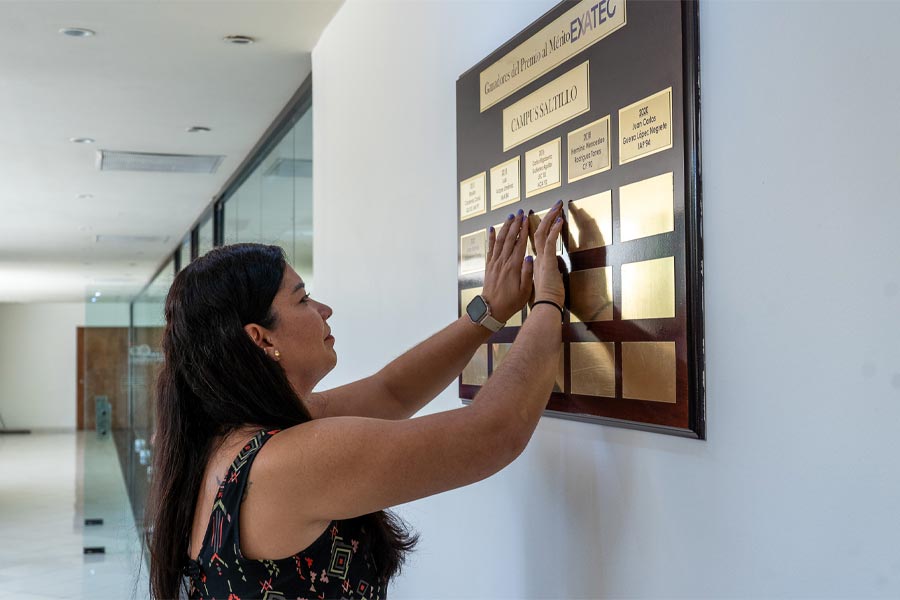 Violetta colocando placa de Premio EXATEC