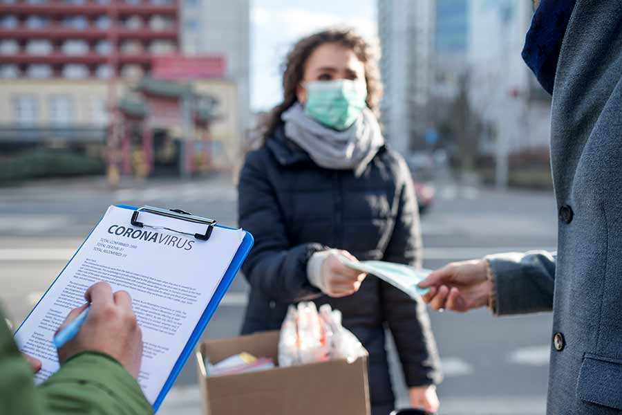 Mujer recibe tapabocas ante contingencia por la enfermedad COVID-19