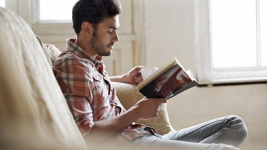 hombre leyendo en un sillon