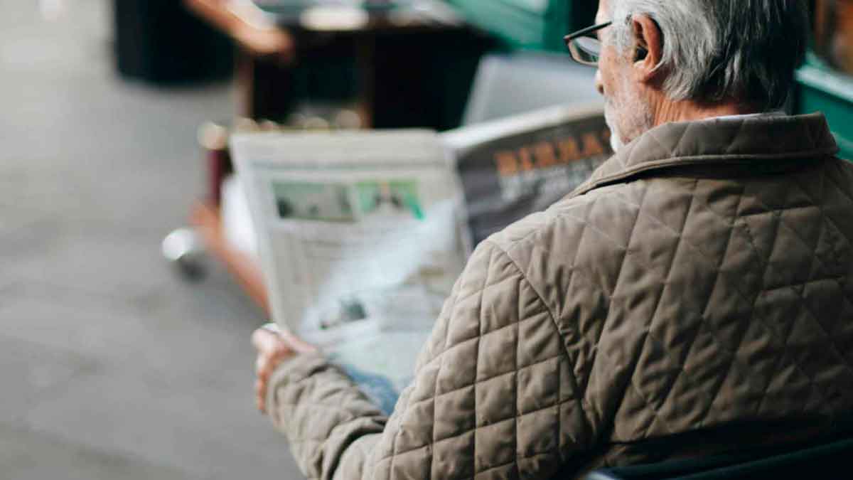 Persona sentada leyendo un diario