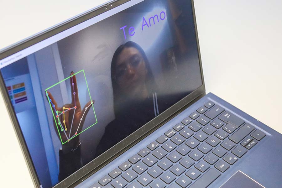 Pantalla de laptop donde se ve una persona diciendo "Te amo" en Lengua de Se&ntilde;as Mexicana.