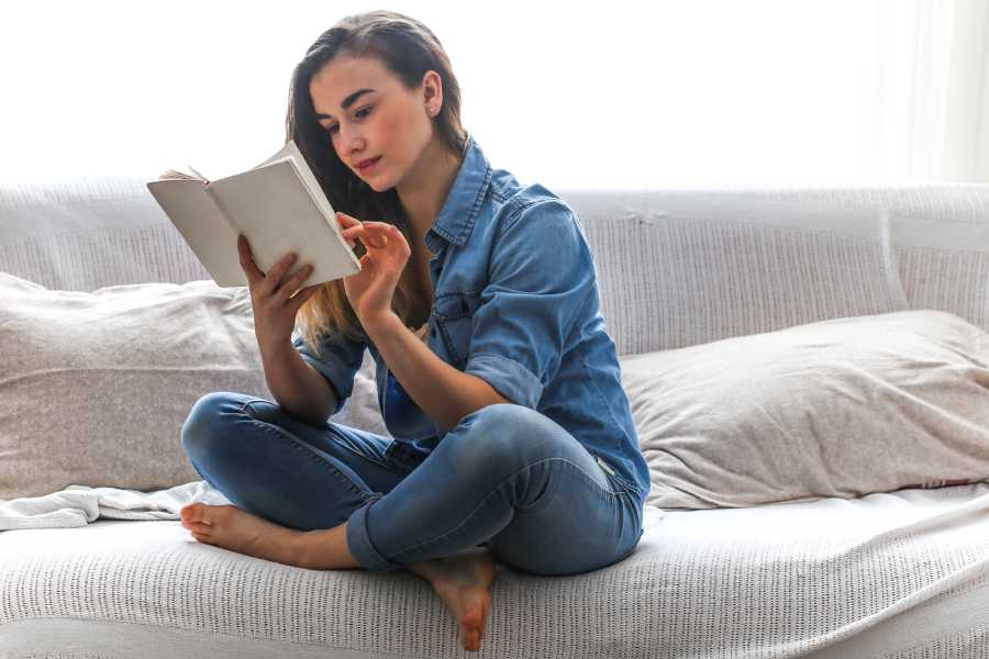 Chica joven leyendo un libro impreso 