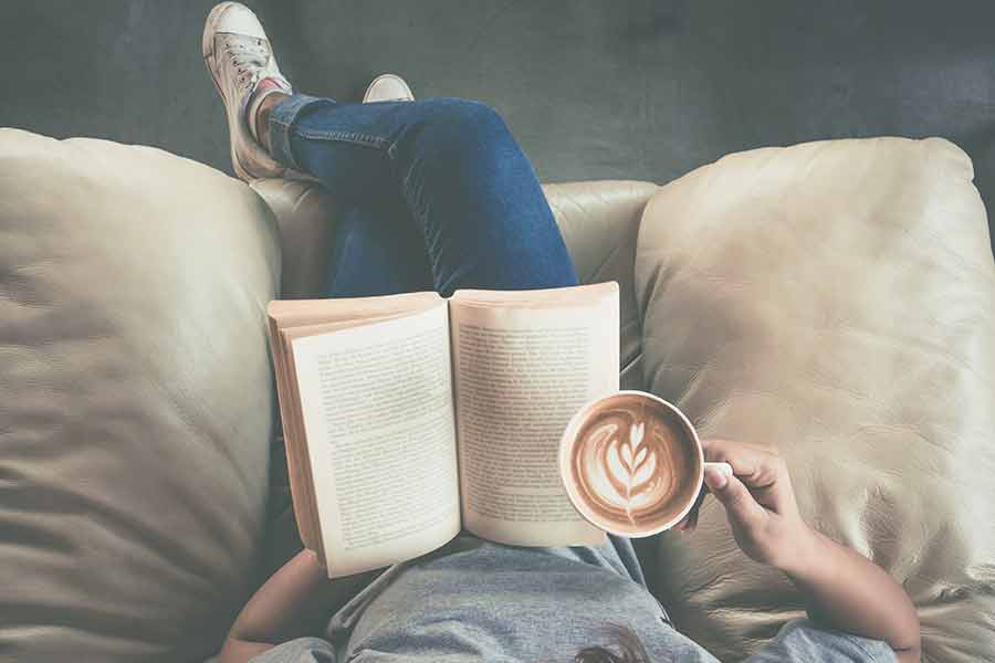 Chica joven leyendo en su sillón