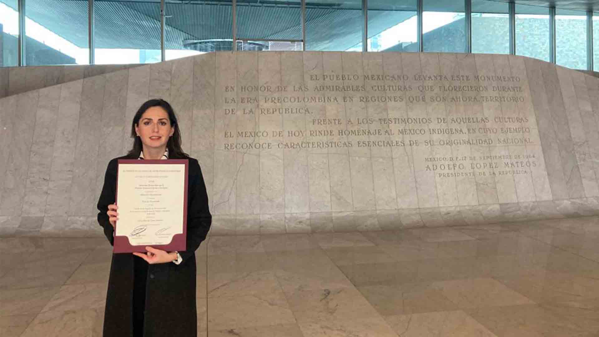 Profesora Silvia Cano recibiendo la mención honorífica