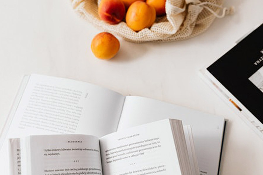 mesa con libros y frutas sobre ella