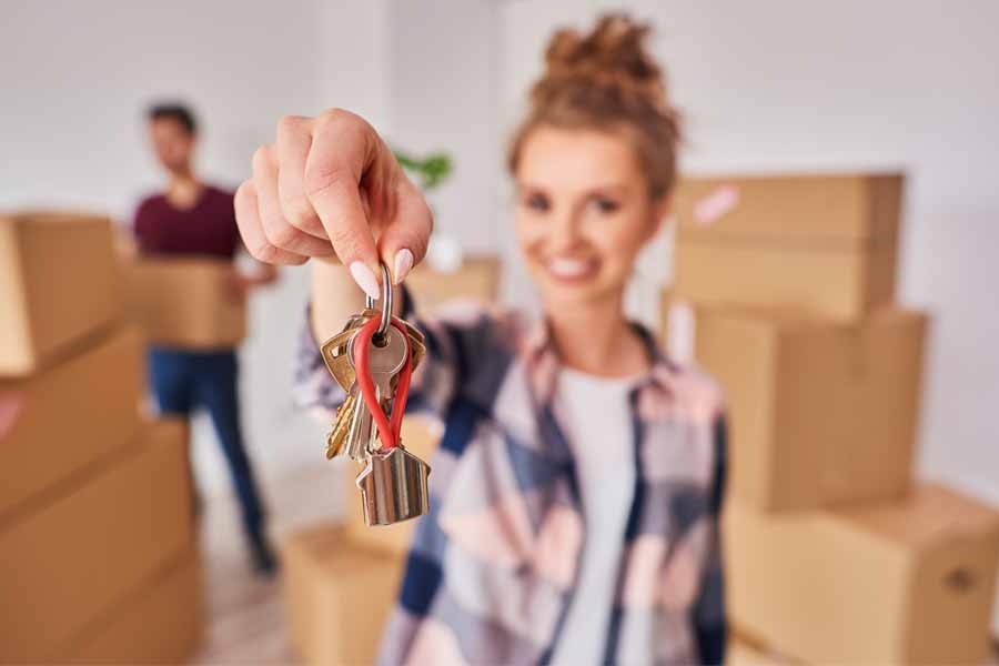 mujer mostrando llaves de una casa pensando si comprar o rentar