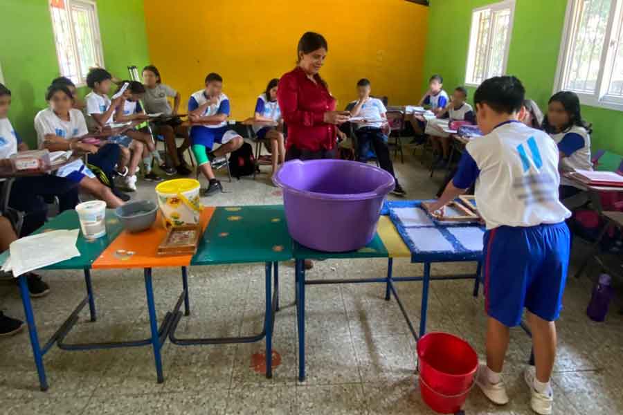 Niños de una escuela de Guatemala aprendiendo a hacer hojas con papel reciclado.