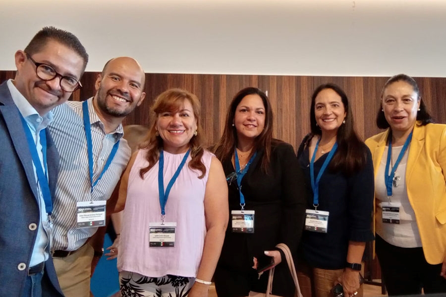 Profesora con otros profesores en congreso internacional