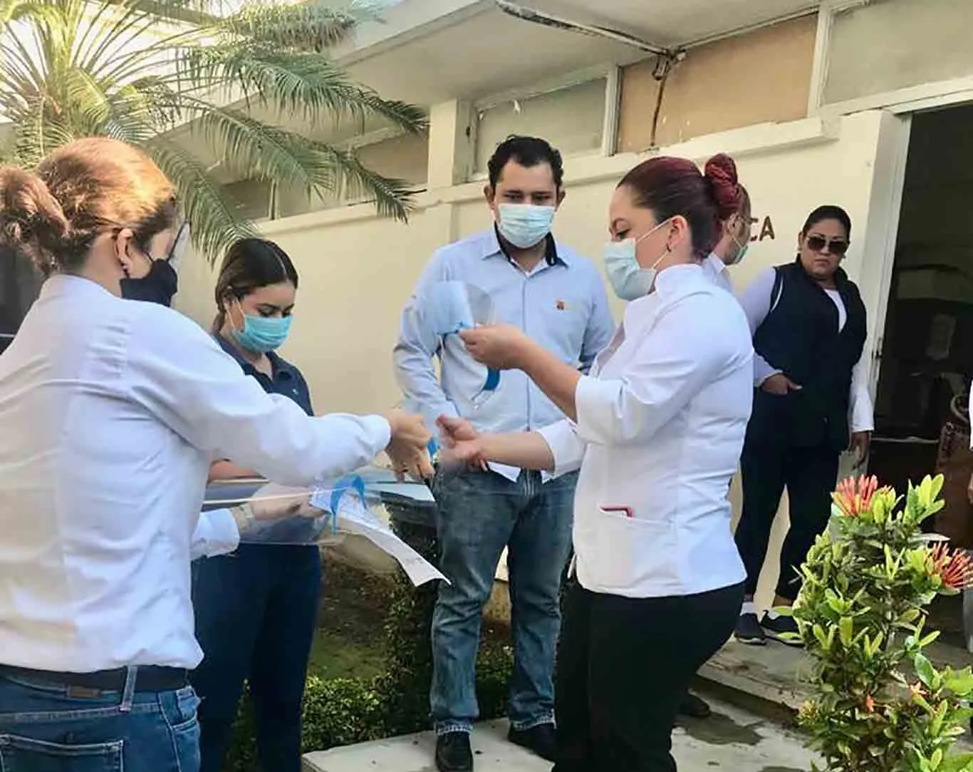 doctor abre paquete de proyecto nabawa de egresadis del Tec con caretas médicas para combatir covid19.