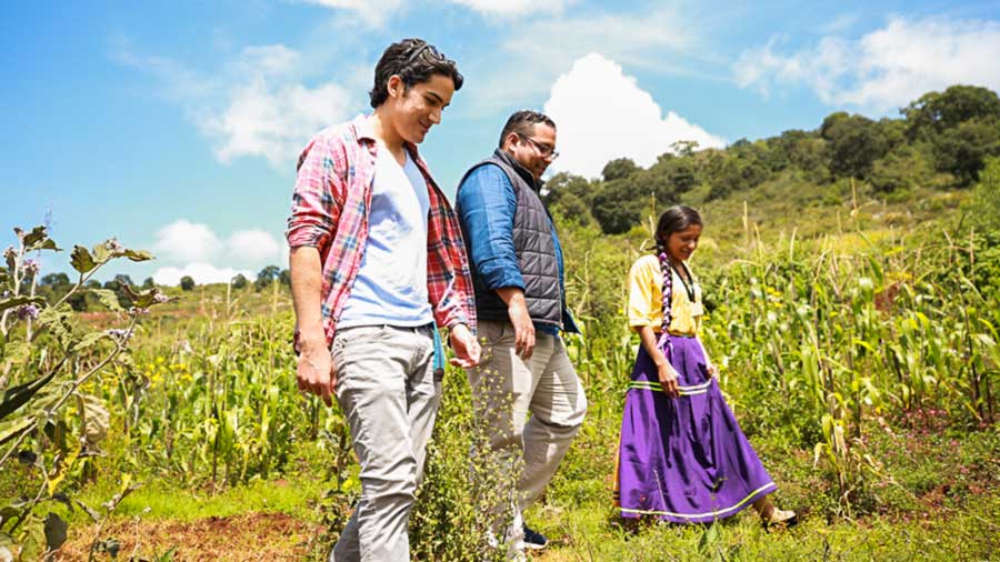 Jovenes caminando junto a mujer indígena