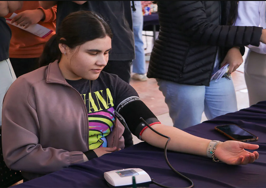 Joven sentada tom&aacute;ndose la presi&oacute;n arterial