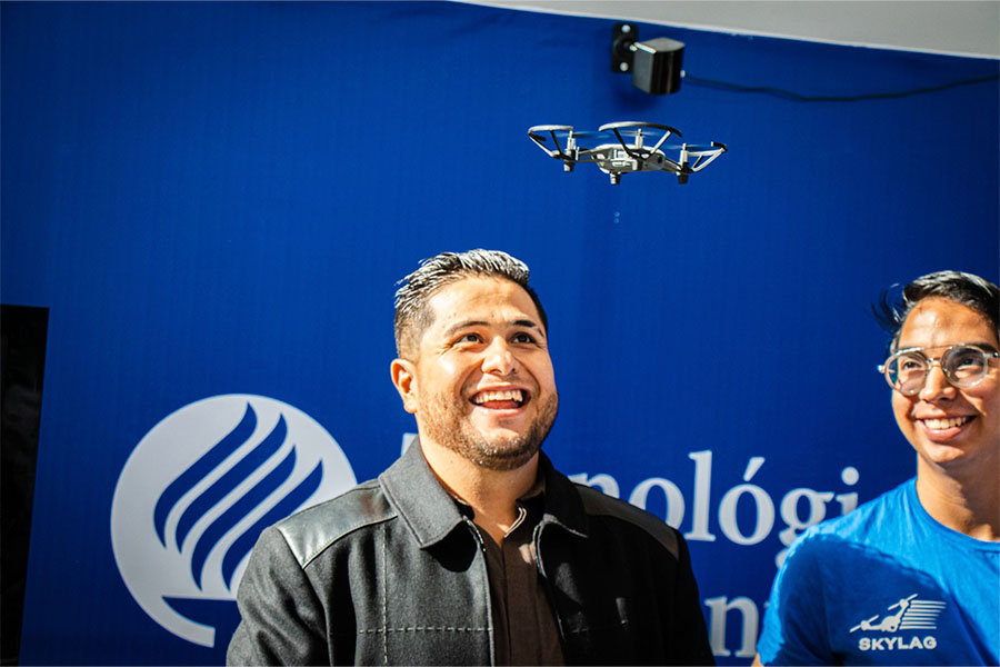 Un dron vuela y una persona sonríe al verlo en el Symposium de Inteligencia Artificial del Tec de Monterrey campus Laguna