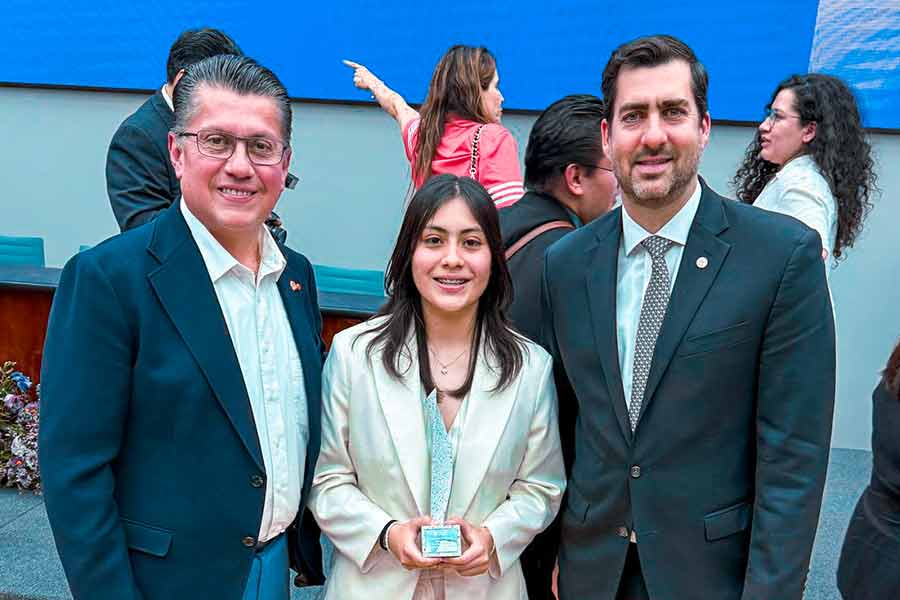 Sara Ramírez recibe Premio Mujer Tec por excelencia, posando junto a dos funcionarios en una ceremonia oficial.