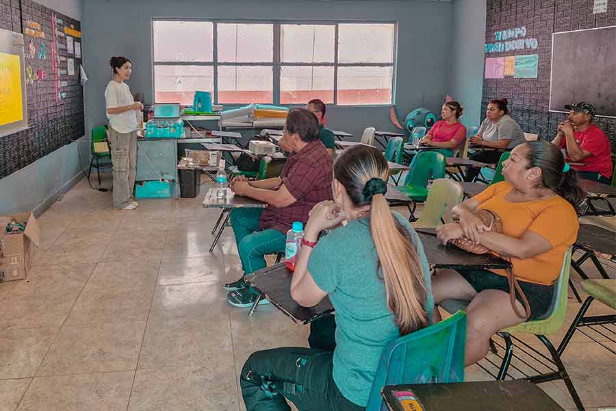 Estudiante de Psicología del Tec de Monterrey campus Chihuahua, impartiendo un taller sobre salud mental a un grupo de adultos en un aula.