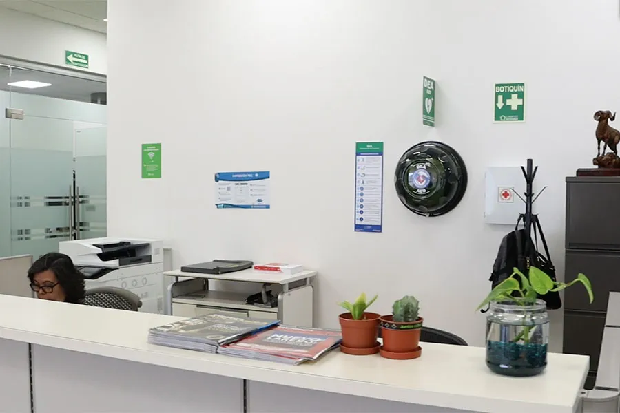 Área de recepción donde se ve un desfibrilador colocado en la pared. 
