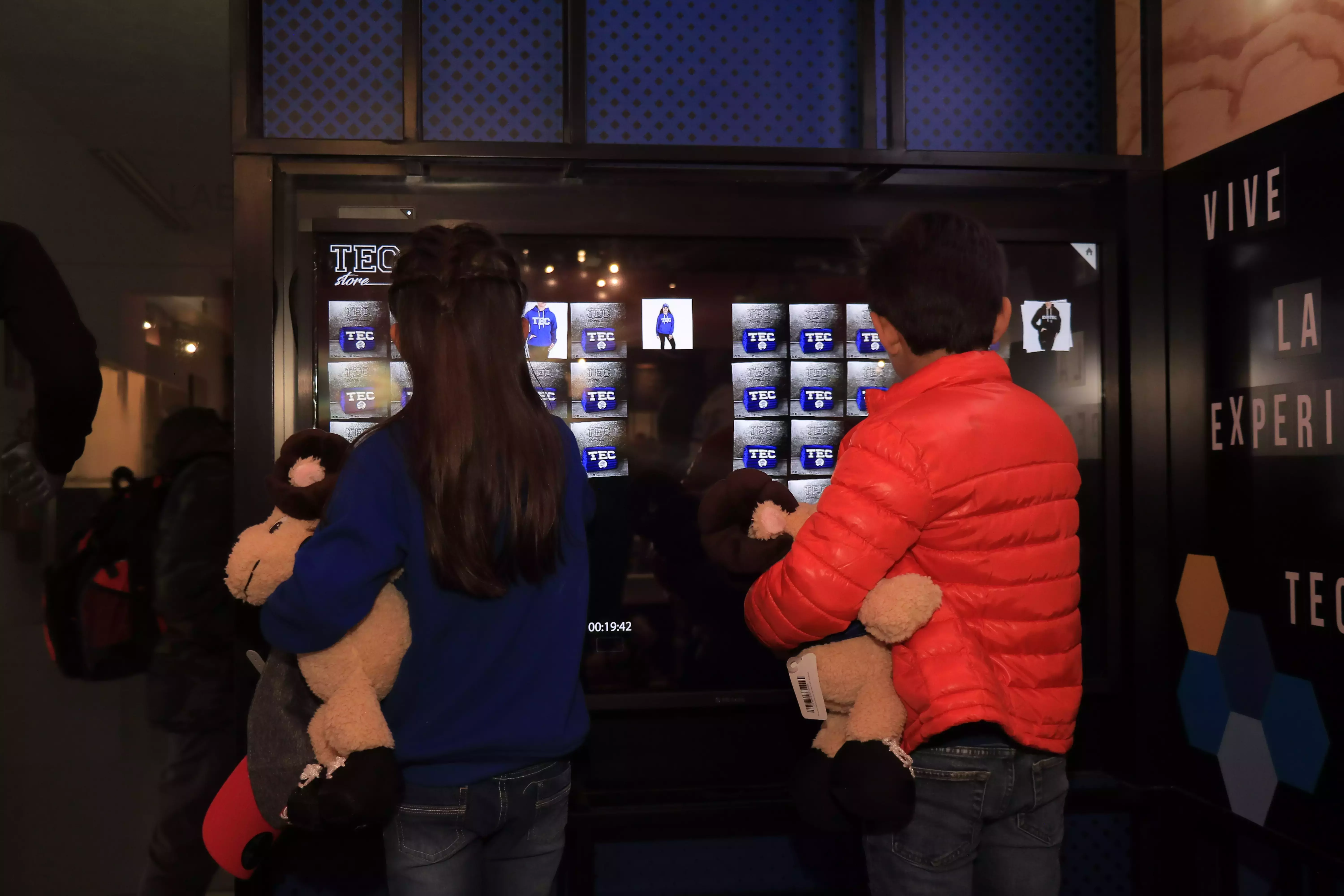 Niños interactuando con la pantalla de Tec Store 