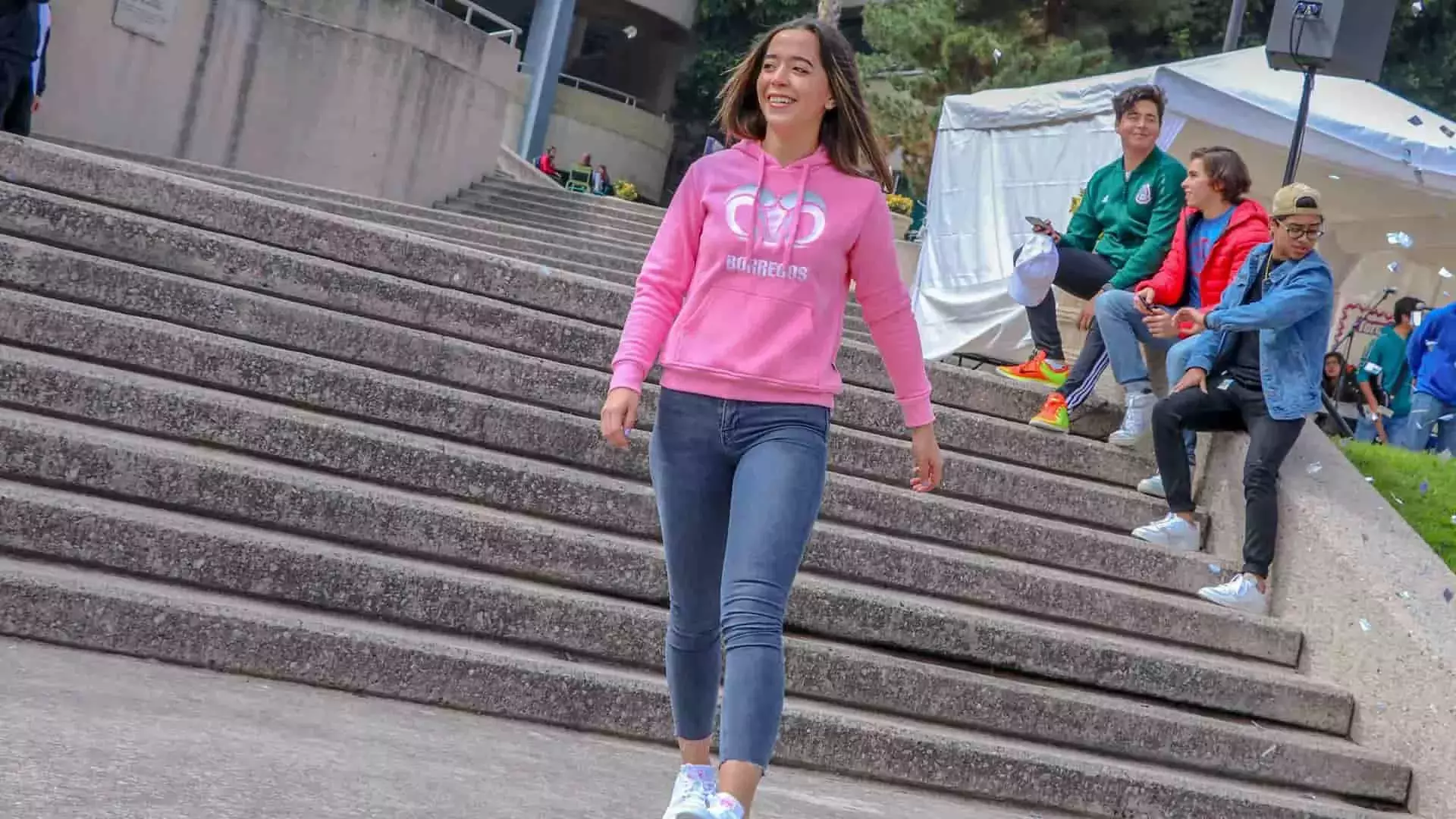 Chica modelando en pasarela sudadera rosa con bordado tec