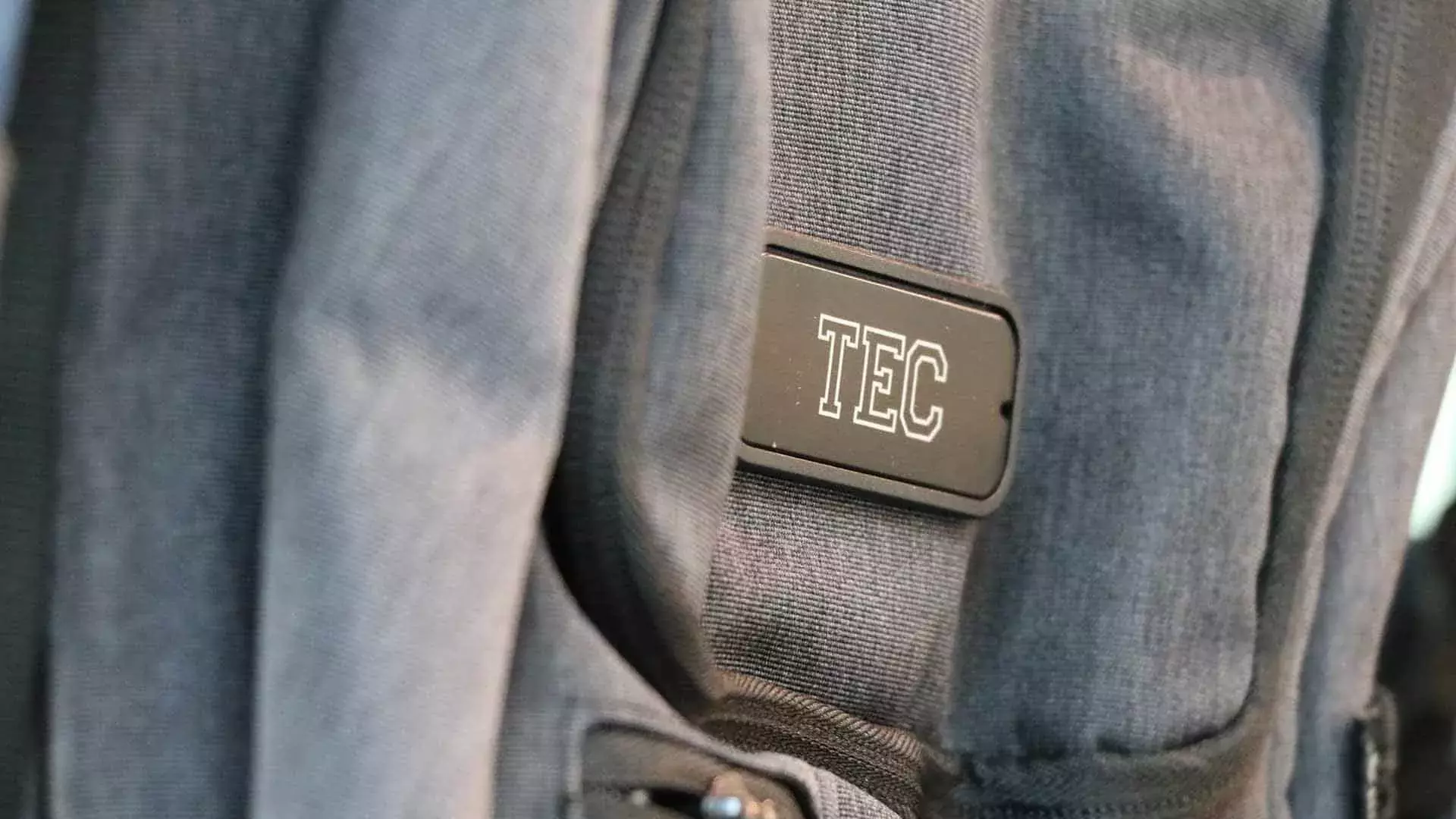 Mochila gris opaca con logo Tec en el centro