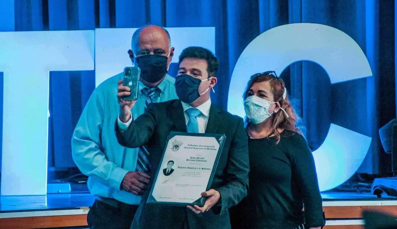 Familia tomándose una selfie con título universitario.